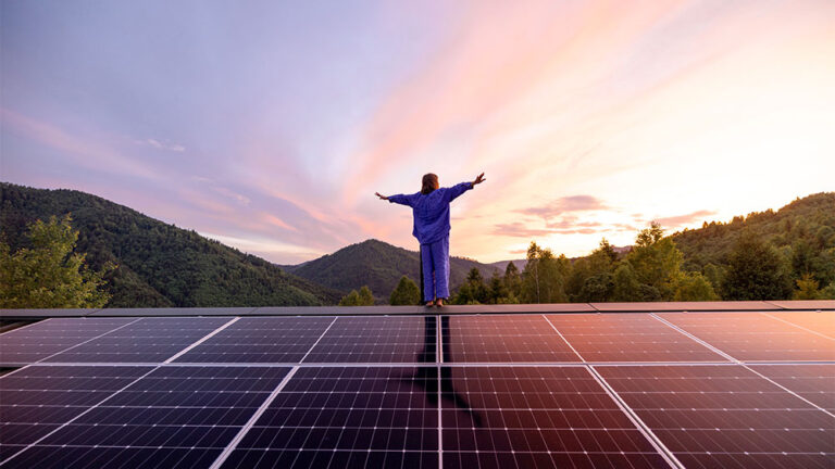 Mulher em cima do telhado de uma casa com painéis solares